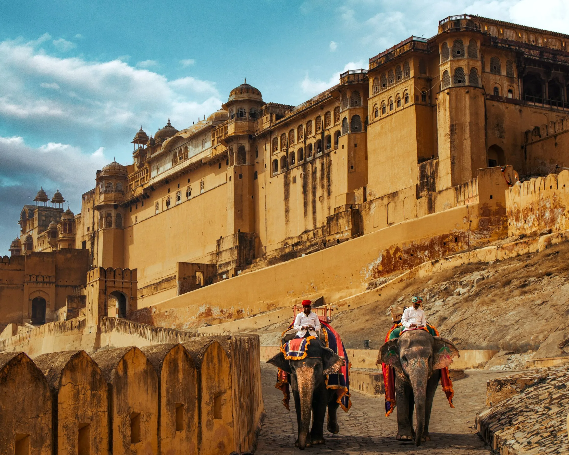 Two guests from our India Group Tour on the Golden Triangle Tour with Travel With Vasco enjoy a majestic elephant ride up to the historic Amber Fort in Jaipur, Rajasthan.
