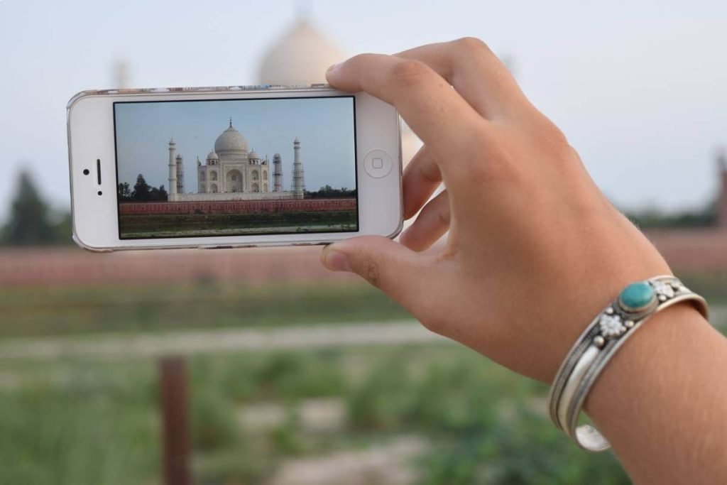India Tour Packages 5 A traveler from Travel with Vasco’s India Group Tour capturing the iconic Taj Mahal on their smartphone during a Golden Triangle Tour.