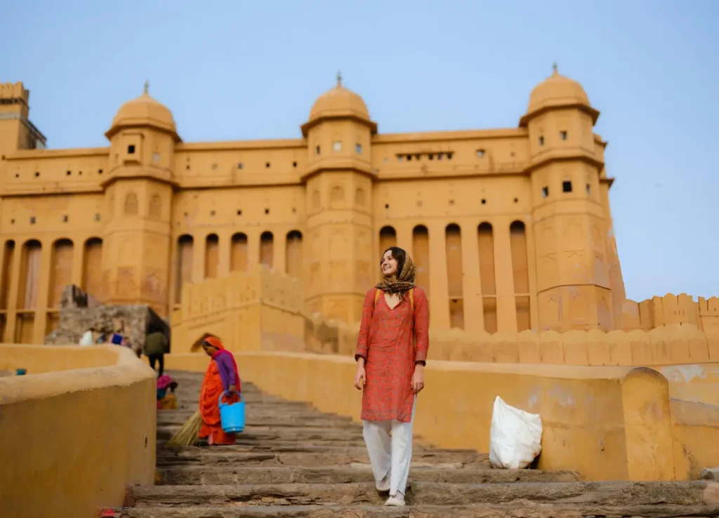 Woman walking on stairs on the background of Amber fort
