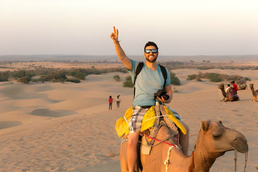 Group Or Solo? What Kind Of India Tour Will Suit You The Best? 1 tourist riding camel in desert
