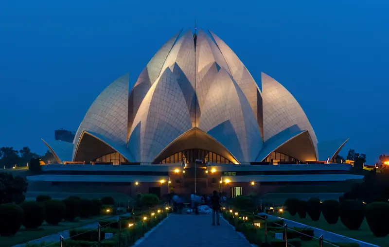 The Lotus Temple illuminated at dusk, a stunning architectural landmark in Delhi, visited during an India Group Tour as part of the golden triangle tour by Travel With Vasco.