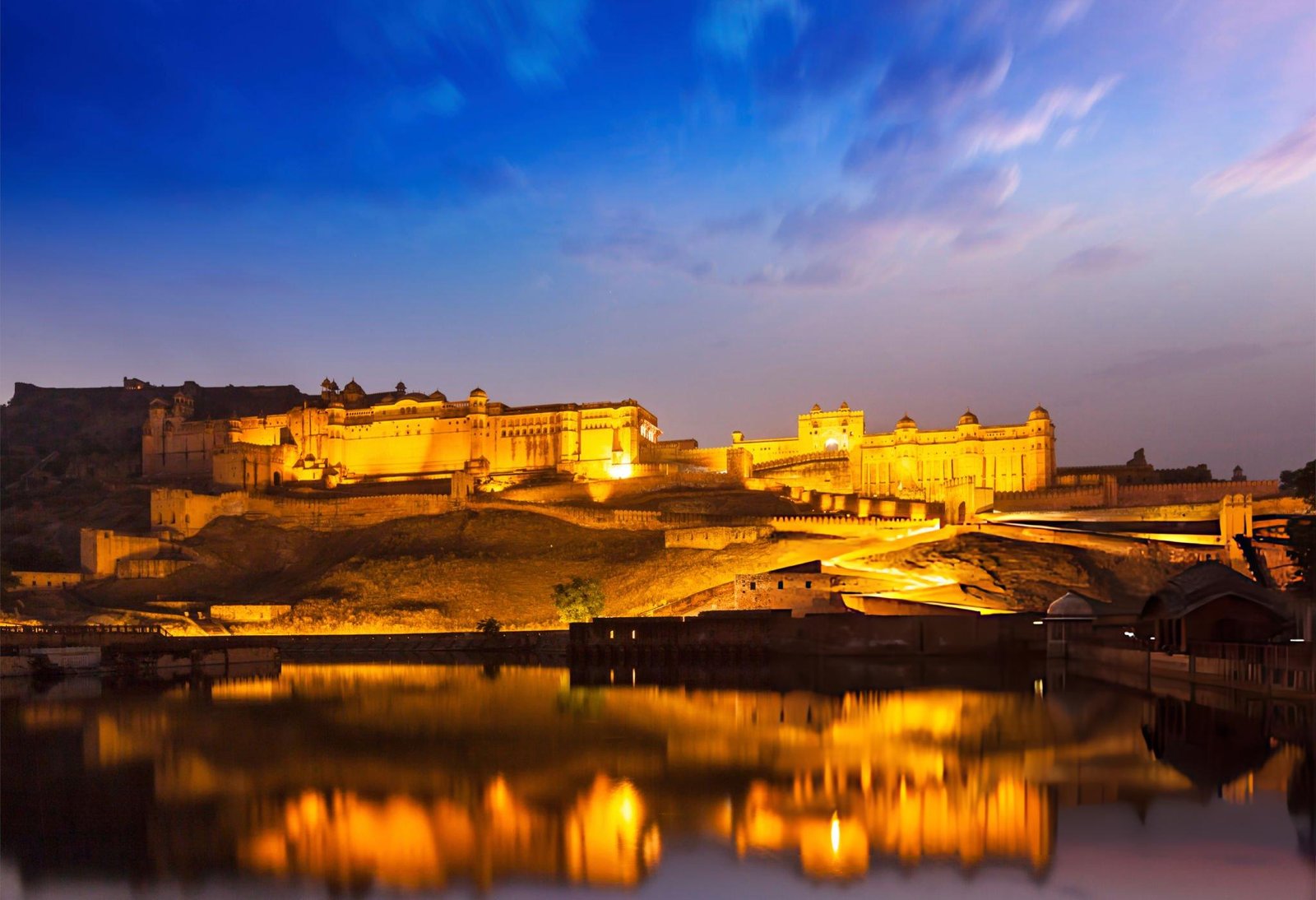 "Amer Fort in Jaipur, beautifully illuminated at night, a highlight of Travel With Vasco's India Group Tour experience."