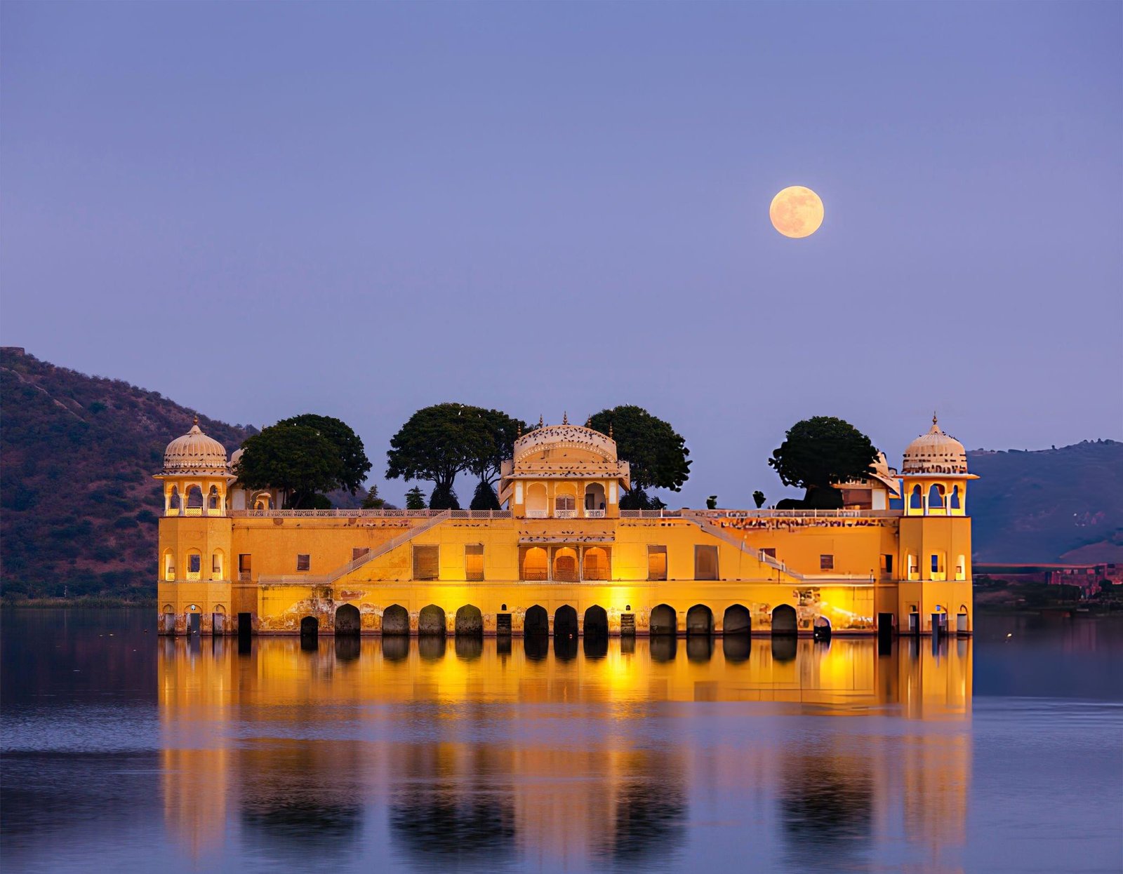 Jal Mahal in Jaipur, India, beautifully illuminated under a full moon, experienced by Travel with Vasco's guests during their India Group Tour.