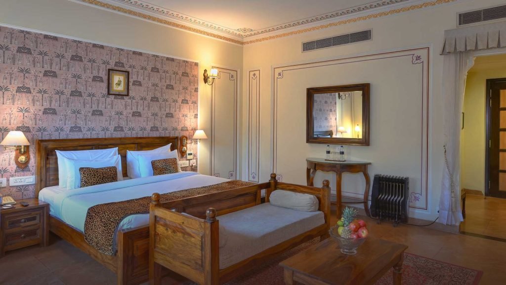 Is Jaipur suitable for family travel? 1 "Luxury hotel room with wooden furniture, designed for guests on an India Group Tour with Travel With Vasco. Ideal for a relaxing stay during the Golden Triangle Tour."